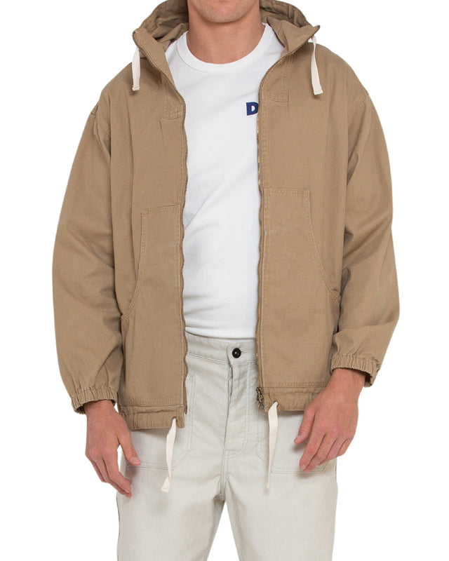tan relaxed fit parka with elasticated cuffs and adjustable drawstring hem, large front pockets, two way zip opening, wind and rain resistant in a 100% cotton canvas fabrication with dry wax finish