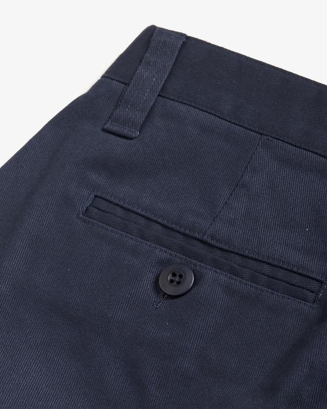 Navy slim fit short with zip fly closure, back welt pockets, coin pocket detail, 63% poly 34% cotton 3% spandex twill fabrication with a garment wash